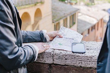 意大利托斯卡纳锡耶纳一对旅游夫妇看着墙上的地图图片