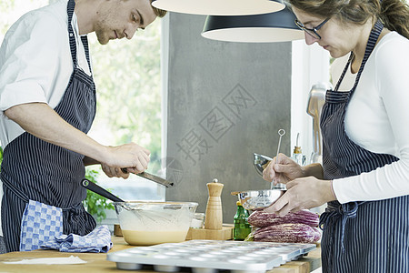 两位厨师在餐桌上工作准备食物图片