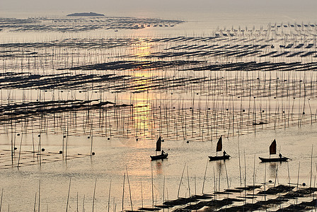 日落海上的渔船图片