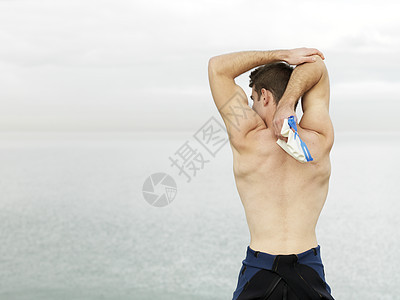 男子在海边做拉伸运动图片