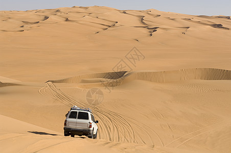 撒哈拉沙漠利比亚费赞沙漠上行驶的越野车图片