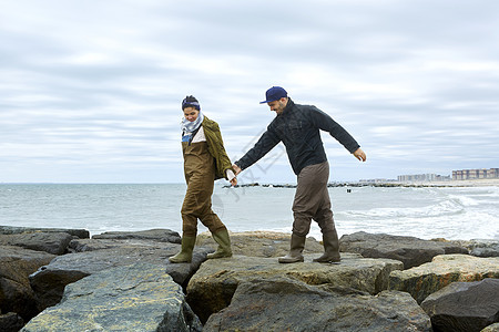 年轻的海鱼夫妇在滩岩石上跳过边图片