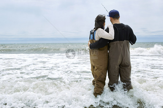 在瓦德海钓鱼中年轻夫妇的背影图片