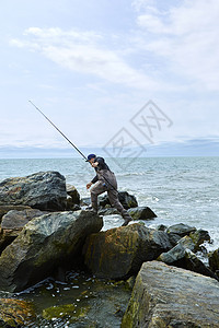 年轻的男海鱼渡过滩岩石图片