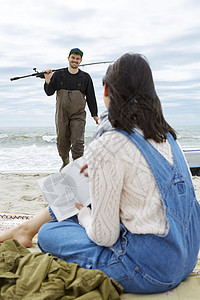 年轻女子在海滩上看着钓男友图片