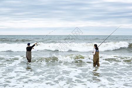 在大海海滩边钓鱼的情侣图片
