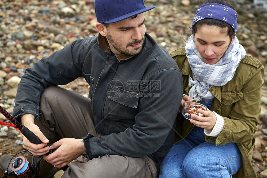 坐在海滩上的年轻夫妇图片