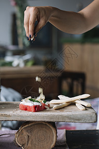 在切割板上制作素食菜盘子的妇女图片