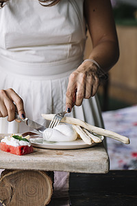 在切割板上制作素食菜盘子的妇女图片