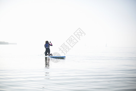 女滑板车手在迷雾的海上划出去后视线图片