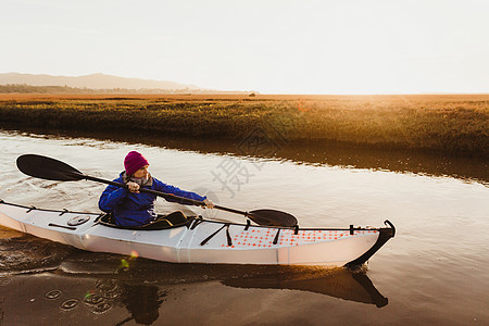 美国加利福尼亚州MorroBay日落时在河上划皮艇图片