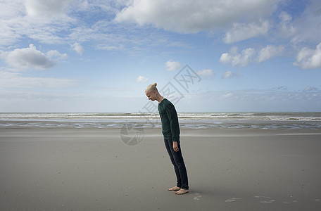 男孩站在沙滩上风暴中向前倾斜法国北帕德加莱州格雷夫林斯图片