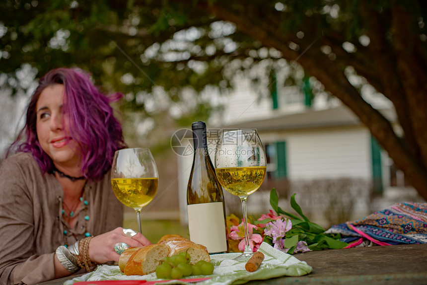 女人在花园里用葡萄酒放松图片