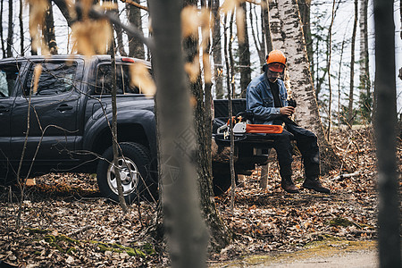 男伐木工人坐在秋季森林里的皮卡上图片