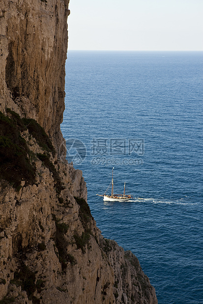 海岸悬崖和船只的景象意大利撒丁岛卡波西亚图片