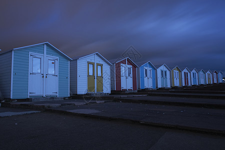 夜间海滩的一排小屋图片