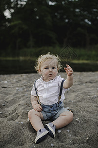 坐在湖边沙滩上的男宝宝图片