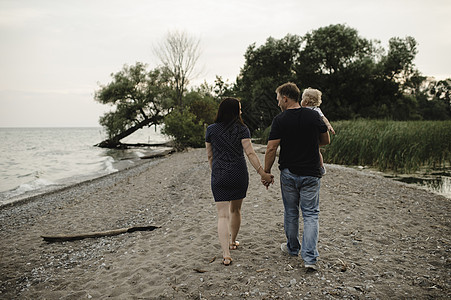 在加拿大安略湖与儿子一起在海滩上漫步的情侣图片