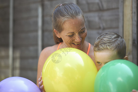 母亲和儿子在花园中抱着气球图片