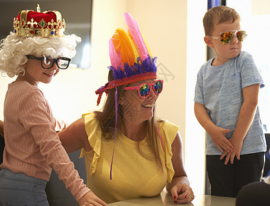 母亲儿子和女儿戴有趣的帽子和眼镜笑着图片