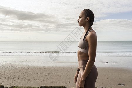 年轻女人在海滩上远望的侧脸图片