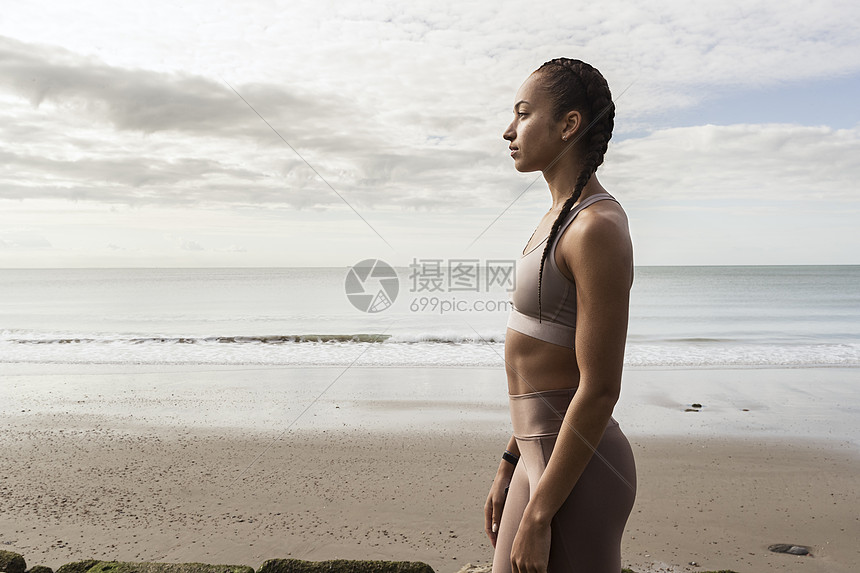 年轻女人在海滩上远望的侧脸图片