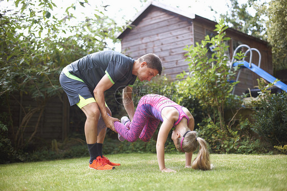 父亲和女儿在花园做热身运动图片