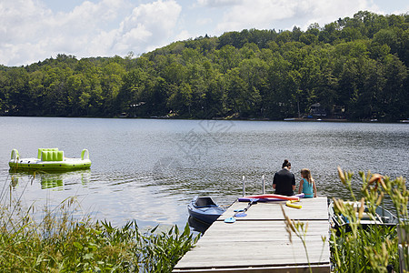 两个女孩坐在湖边图片