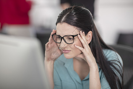 有压力的年轻女办公室员工在看台式计算机图片
