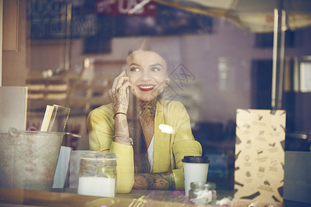 坐在咖啡厅的年轻女性使用手机图片