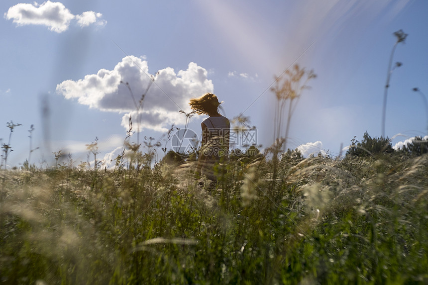 头发被风吹起的人站在野外看风景的背影