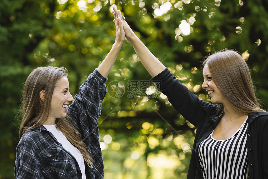 两个年轻女人在公园中击掌