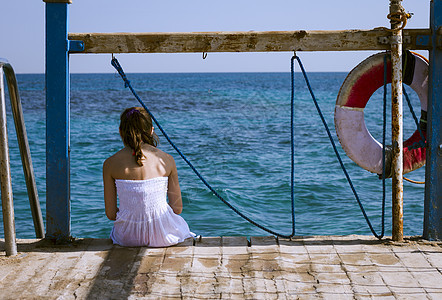 坐在码头看着大海的女孩背影图片