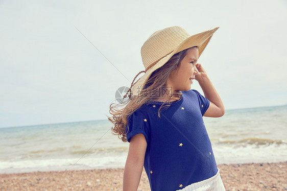 年轻女孩站在沙滩上远望图片