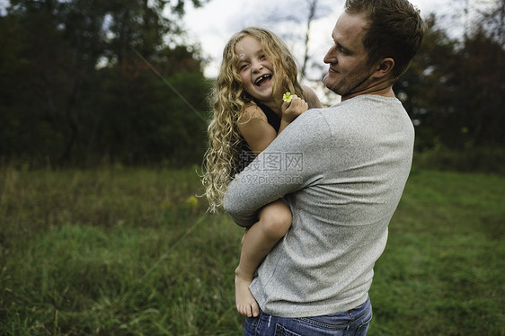 父亲和女儿在绿草地上户外活动图片