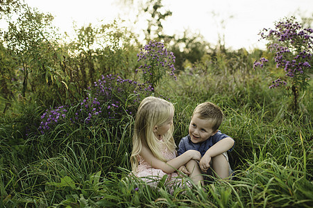 男孩女孩坐在草地上图片