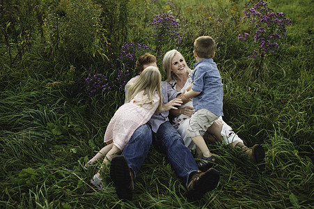 父母和子女一起躺在草地上图片