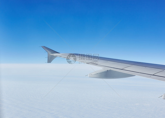 云层上空飞行的机翼图片