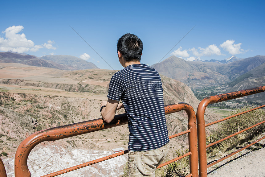 一名男子倚在栏杆上眺望风景
