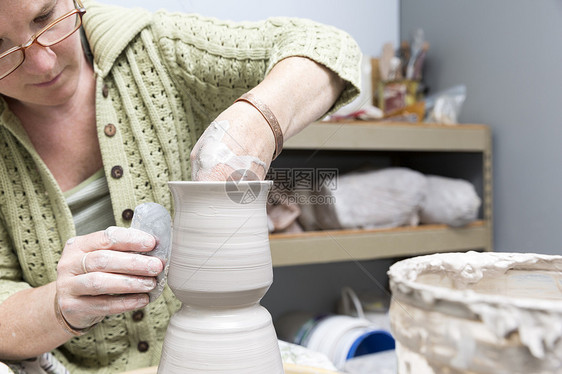 女人在陶轮上制作陶器图片