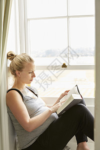 孕妇在窗口阅读高清图片