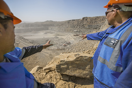 采石场的两名采石工人手指着远处讨论图片