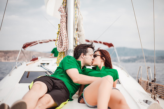 一对躺在帆船接吻上的情侣图片