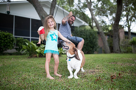 父亲和女儿和宠物狗在花园图片