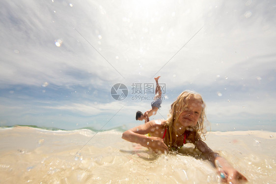 女孩躺在浅水海滩上哥在准备倒立站着图片