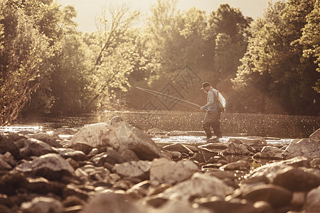 渔民站着深到脚踝的河水里抓鱼斯洛文尼亚图片