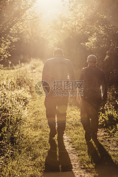 日落时在斯洛文尼亚布列佐维奇的两名渔民在林地散步图片