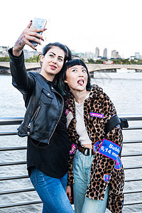 2名年轻时尚女在千禧桥上用手机自拍图片