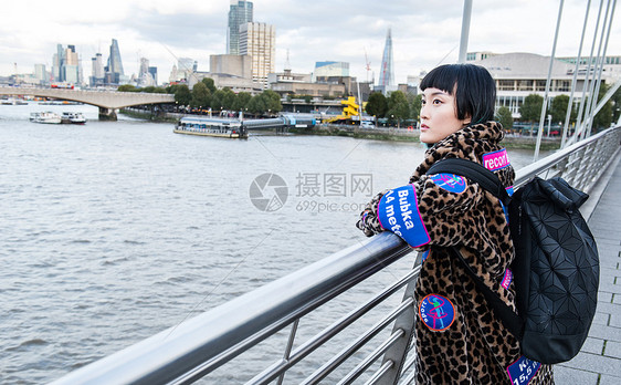 站在千禧桥上的时尚年轻女人图片