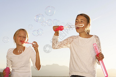 两个年轻女孩在户外吹泡泡图片